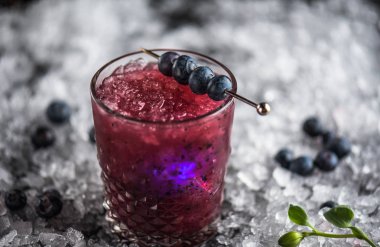 Stick buz ile koyu arka plan üzerinde yaban mersini taze kokteyl cam süslenmiş