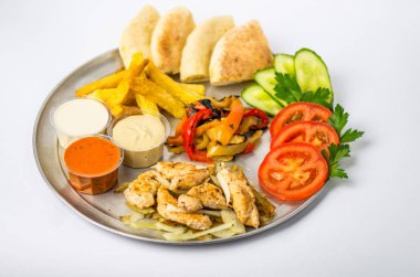 çerez tabağı taze ve kızarmış sebze, tavuk, soslar ve beyaz zemin üzerine ekmek