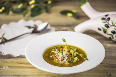 Ahşap masa üzerinde beyaz tabakta sebze çorbası