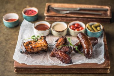 Sos ve salamura sebze ile ahşap tahta üzerinde ızgara et ve sosis