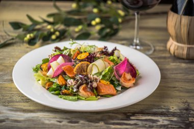 Ahşap masa üzerinde beyaz plaka üzerinde kızarmış tavuk ile sebze salatası