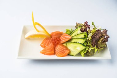 Kırmızı havyar ve beyaz arka plan üzerinde tabakta servis sebze taze somon balığı