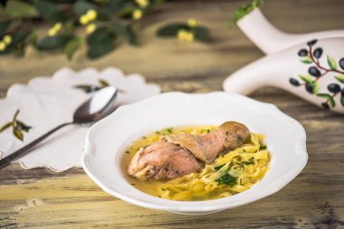 Tavuk çorbası erişte ile ahşap masa beyaz tabakta servis