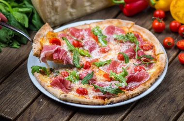 et, roka, parmesan ve kiraz domates gurme pizza ahşap masa üzerinde görmek