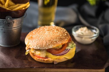 Lezzetli burger ahşap tahta üzerinde patates kızartması ile