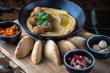 Ev yapımı humus ile farklı meze ve Pide ahşap tahta üzerinde kase
