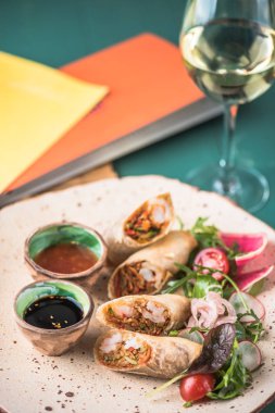 Bahar rulo bardak beyaz şarap Restoran tablo ile plaka üzerinde sos ile