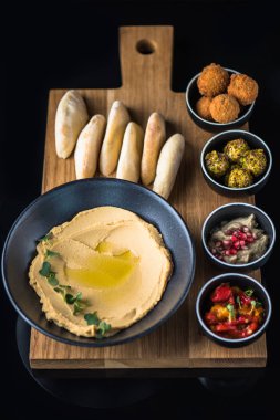 Ev yapımı humus ile farklı meze ve Pide ahşap tahta üzerinde kase