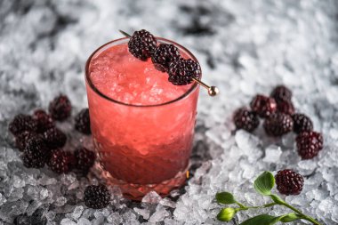 Kokteyl cam buz ile koyu arka plan üzerinde böğürtlen ile dekore edilmiş