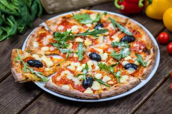 Roka ve ahşap masa tabakta servis zeytin İtalyan pizza