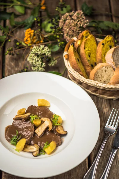 Mantar sos ve patates beyaz tabakta demlenmiş sığır eti
