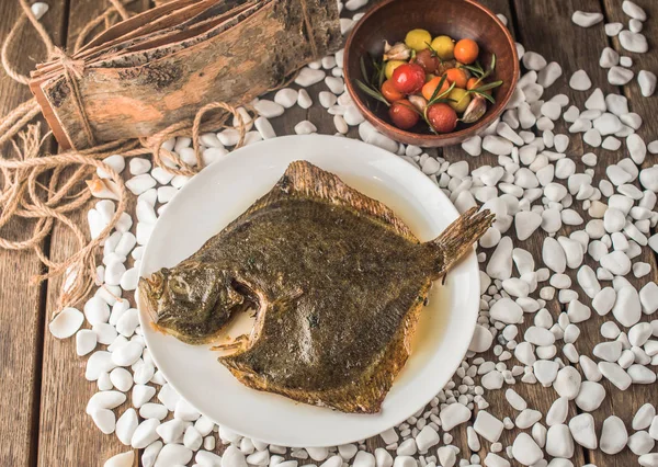 野菜のボウルで木製テーブルの上皿の唯一の魚のグリル — ストック写真