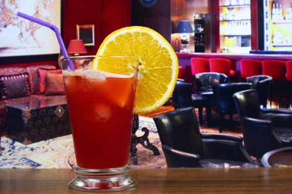 Plantation punch cocktail in hurricane glass with straw and orange slice