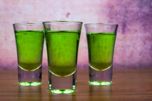 Three glasses of absinthe in a shot glass