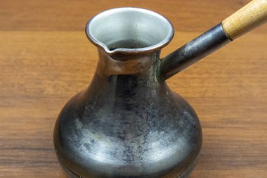 Ahşap masada kahve yapmak için bakır cezve