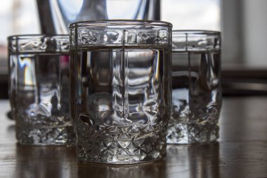 Üç bardak votka ahşap bir masa üzerinde