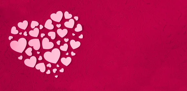 PINK HEARTS OF PAPER ON MAGENTA TEXTURED BACKGROUND FOR SAN VALENTIN DAY