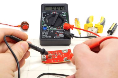Elektrikçi, aynı zamanda beyaz arka plan üzerinde bağlayıcısıyla multimetre için araç kiti.