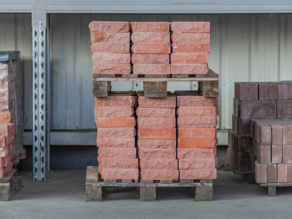 Clay bricks stock pallets stacking at the construction site. Material delivered from factory.