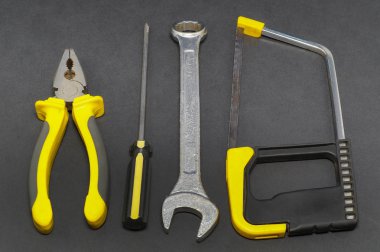 Bir gri arka plan pense, tornavida, teyp, yalıtım araçları bir dizi gördüm.