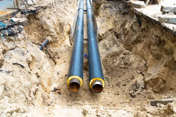 Water pipes in ground pit trench ditch during plumbing under construction repairing.