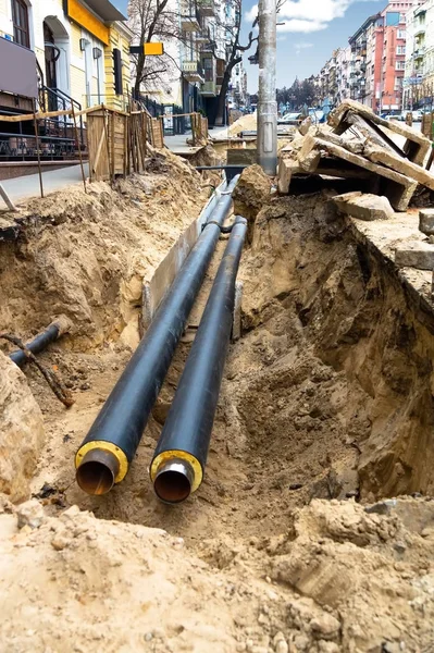 Water pipes in ground pit trench ditch during plumbing under construction repairing.