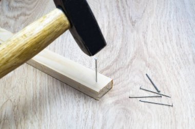 Ahşap blok içine çivi çekiç çekiç.