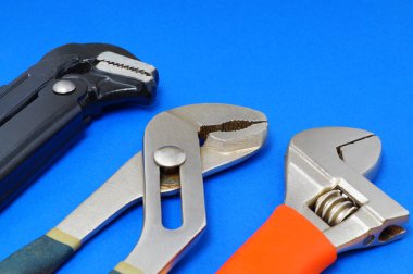 Sıhhi tesisat iş araçları üzerinde mavi bir arka plan.