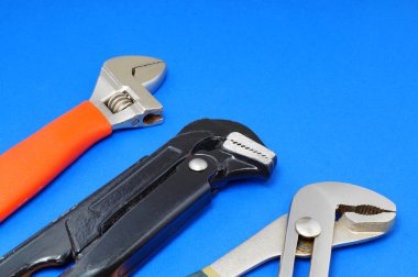 Sıhhi tesisat iş araçları üzerinde mavi bir arka plan.