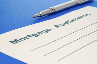 Mortgage uygulaması ile kalem mavi zemin üzerine.