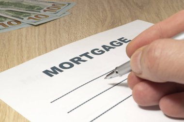 Bir kalemle, para mortgage ve masaya el.