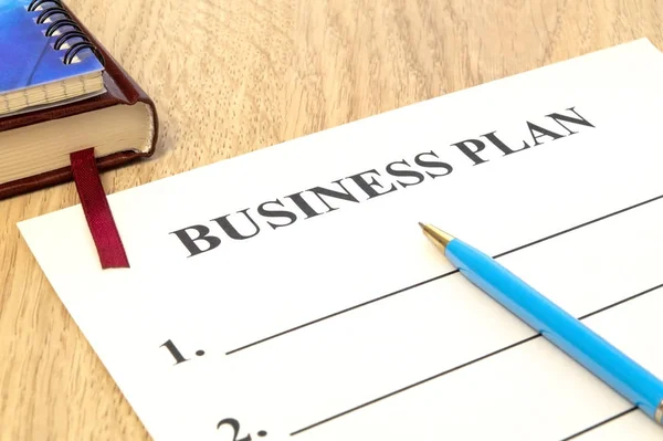 Plan de negocio estratégico con bolígrafo y bloc de notas sobre la mesa . — Foto de Stock