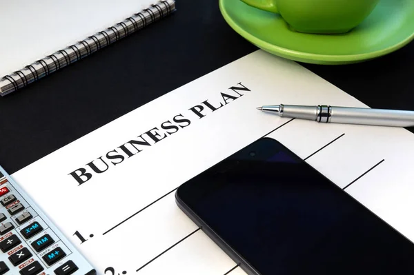 Plan de negocio de estrategia con bolígrafo, café y bloc de notas sobre mesa negra . — Foto de Stock