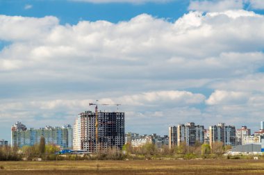 Mavi gökyüzüne karşı şehirde yapım aşamasında olan ev.