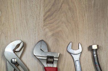 Ahşap arka plan üzerinde tesisatçılar için gerekli araçlar seti.