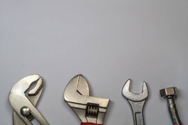 Gri arka plandaki tesisatçılar için gerekli araç seti.