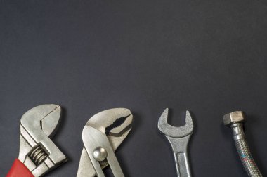 Siyah arka plan üzerinde tesisatçılar için gerekli araçlar kümesi.