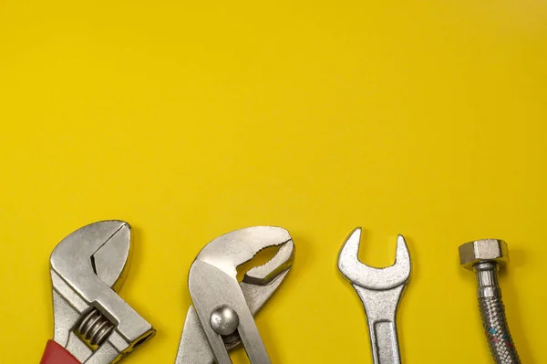 Conjunto necesario de herramientas para fontaneros sobre un fondo amarillo . — Foto de Stock