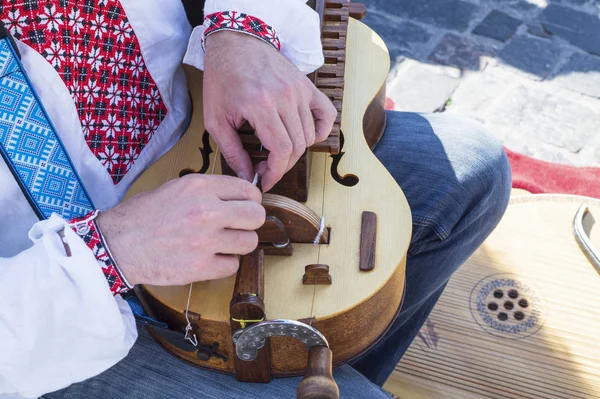 Man on the street plays on the wheeled lyre. — Stock Photo, Image