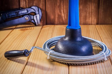 Ahşap arka planda mavi saplı ve kablolu plastik piston temizleyin