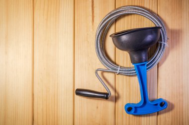 Ahşap arka planda mavi saplı ve kablolu plastik piston temizleyin