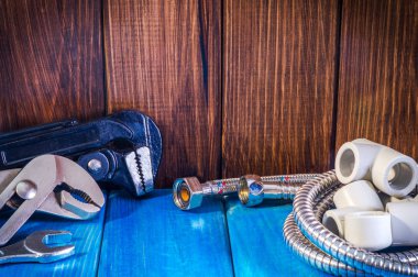 Mavi ahşap arka plan yakın çekim de sıhhi tesisat malzemeleri ve araçları.