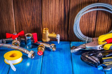 Mavi ahşap arka plan yakın çekim de sıhhi tesisat malzemeleri ve araçları.