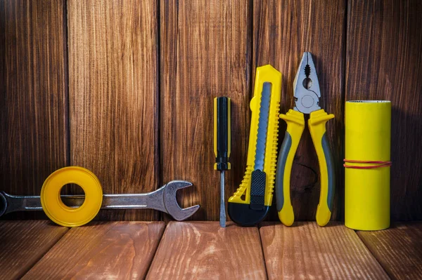 Hand tool on dark wooden background for home work or for locksmith.