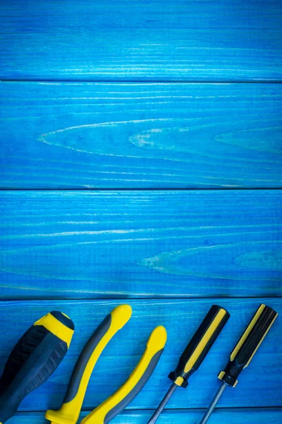 Hand tool on blue wooden background for home work or for locksmith.