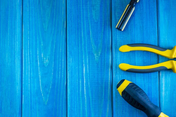 Hand tool on blue wooden background for home work or for locksmith.