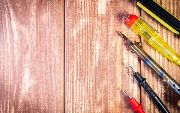 Un conjunto de herramientas para el mantenimiento de la electrónica, sobre fondo de madera . — Foto de Stock