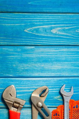 Mavi ahşap arka plan üzerinde tesisatçılar için gerekli araçlar seti.