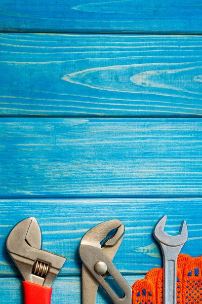 Mavi ahşap arka plan üzerinde tesisatçılar için gerekli araçlar seti.