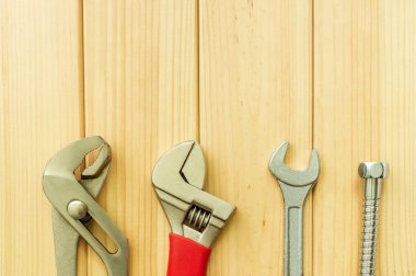 Ahşap arka plan üzerinde tesisatçılar için gerekli araçlar seti.